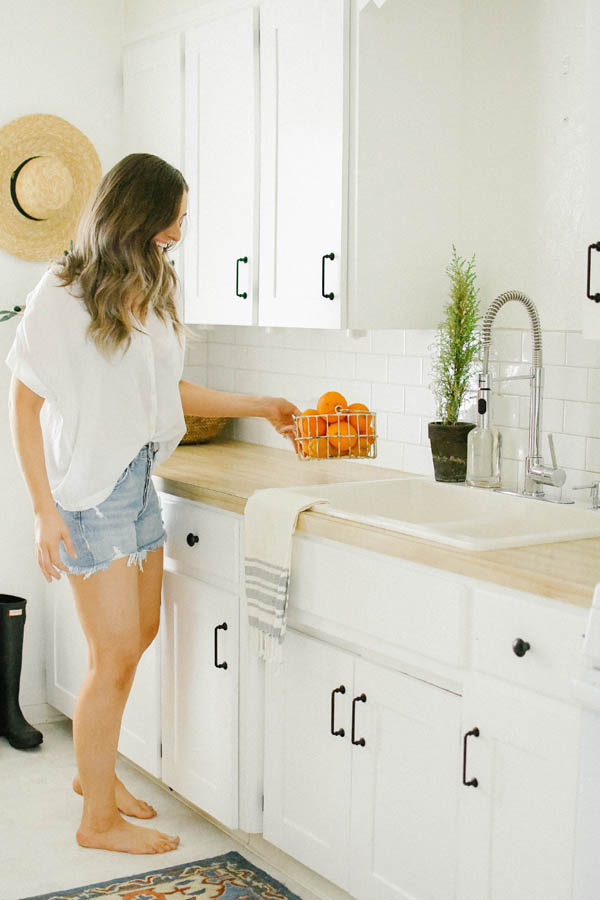 A Bright and White Kitchen A Girl Holding Oranges